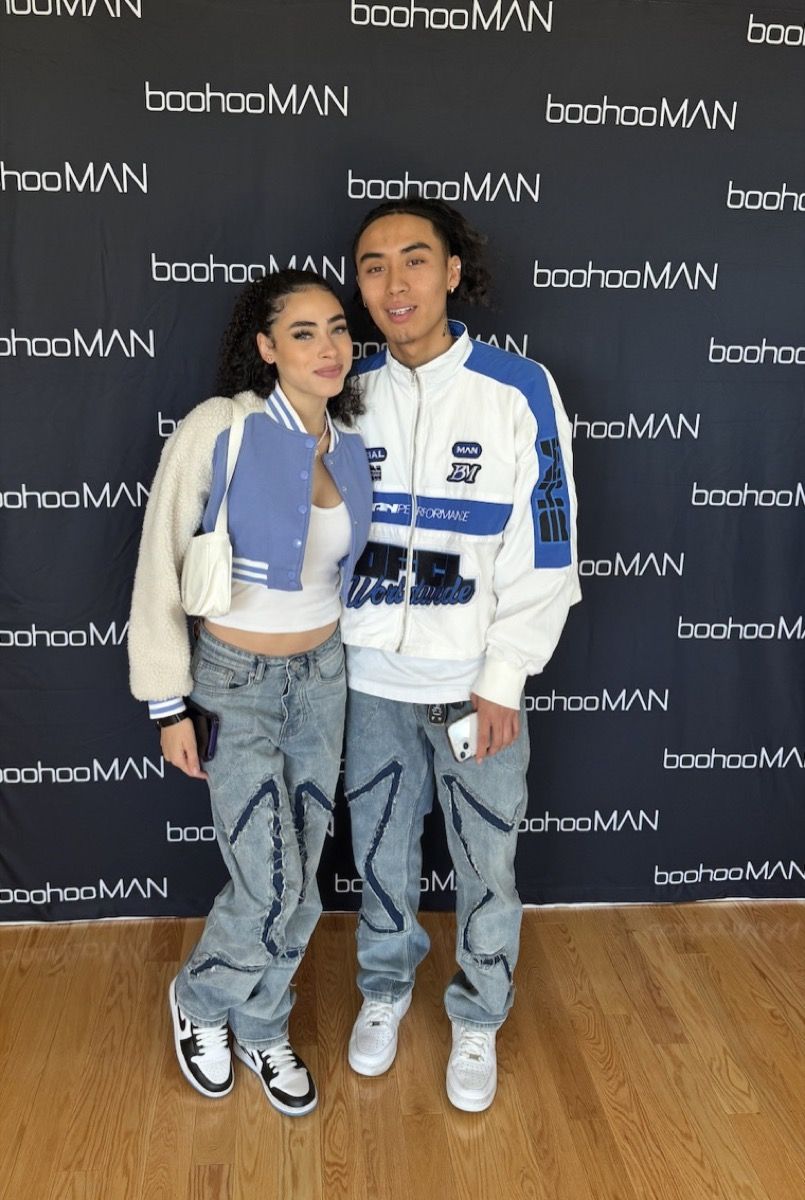 Two creators in gifted boohooMAN outfits at the gifting suite press wall