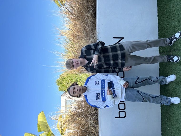 Two creators posing in boohooMAN outfits outside the gifting suite