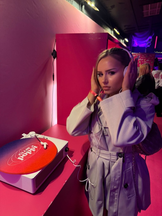 Creator listening on headphones at the Club Poppi vinyl station during the London launch