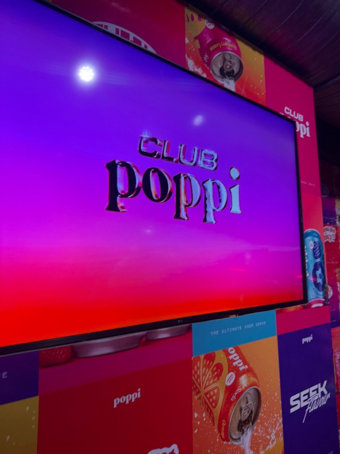 Club Poppi title screen on a display at the London launch event