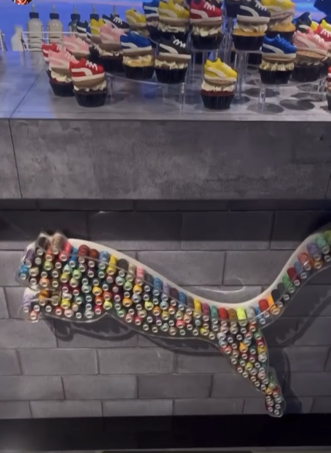 Puma sneaker cupcakes above a Puma leaping-cat logo made of thread spools at the NYC launch